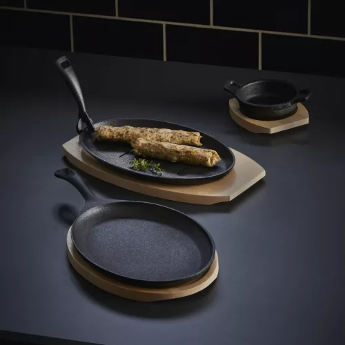 Tálalóserpenyő, ovális, 27×17,5×2 cm, öntöttvas, fa alátéttel