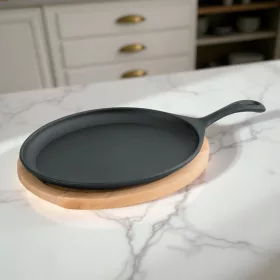   Tálalóserpenyő, ovális, 25×18,5×2 cm, öntöttvas, fa alátéttel